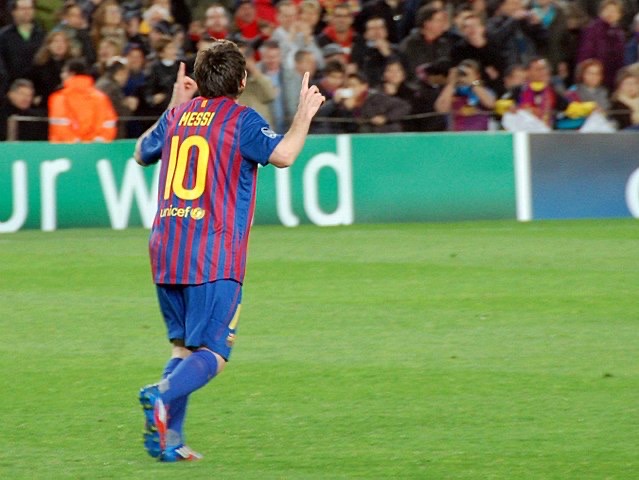 Messi pointing toward the sky in celebration.